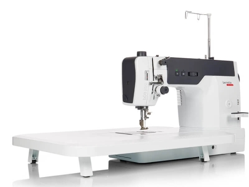 Maszyna do szycia BERNETTE 08 Straight Stitch w kolorze białym, z prostokątnym blatem. Widoczny mechanizm szyjący z igłą oraz panel sterujący z przyciskami. Ujęcie z boku, ukazujące detal konstrukcji i funkcjonalności urządzenia.