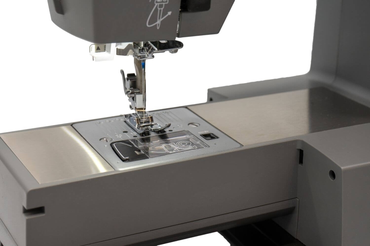 Maszyna do szycia Redstar RQ60 Heavy Duty, widok z boku na igłę i stopkę, metalowa powierzchnia robocza, wyraźne oznaczenia na płycie, elementy sterujące w pobliżu. Produkt leży na płaskiej powierzchni, w neutralnym tle.