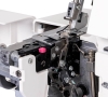Owerlok Janome 454D z widocznym wnętrzem maszyny, metalowymi elementami oraz różowym przyciskiem do szybkiego nawlekania. Zestaw 7 ściegów, 3/4-nitkowy, z wbudowanym mechanizmem do regulacji napięcia nici.