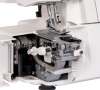 Owerlok Janome 454D, widok z boku, z odkrytą obudową. Wnętrze maszyny ukazuje mechanizm szycia, w tym elementy nawlekania i regulacji. Białe i metaliczne detale, wyraźnie widoczne pokrętła oraz dźwignie. 7 ściegów, 3/4-nitkowy.