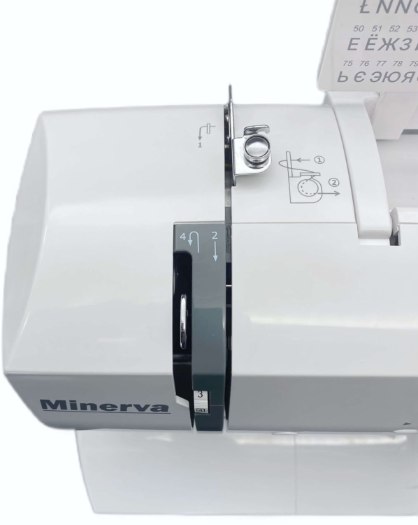 Maszyna do szycia Minerva Experience 2000 w kolorze białym, widok z góry. Na panelu znajdują się numery i ikony instrukcji szycia, a na obudowie widoczne logo Minerva. Uchwyt do przesuwania igły oraz elementy regulacji są wyraźnie widoczne.