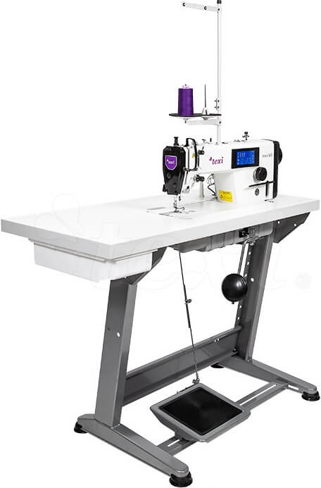 Stebnówka TEXI TRONIC 6 NEO PREMIUM, 1-igłowa, umieszczona na stabilnym stole. Widoczne elementy: biała obudowa, panel sterujący z wyświetlaczem, szpula fioletowej nici. Maszyna przeznaczona do szycia lekkich i średnich materiałów.