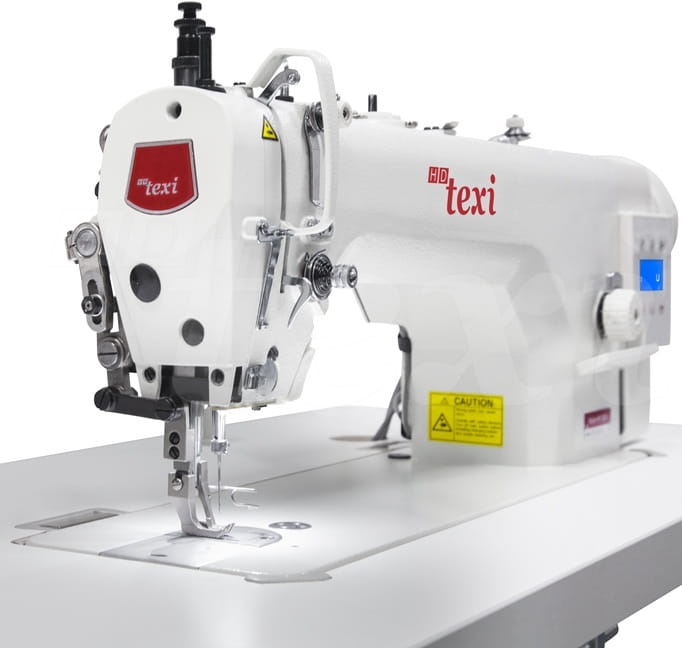 Stebnówka TEXI WALKER WF SERVO PREMIUM w kolorze białym, z transportem dolnym i kroczącą stopką. Widoczna igła, mechanizm z logo texi oraz panel sterujący po prawej stronie. Stół maszyny z jasną powierzchnią.
