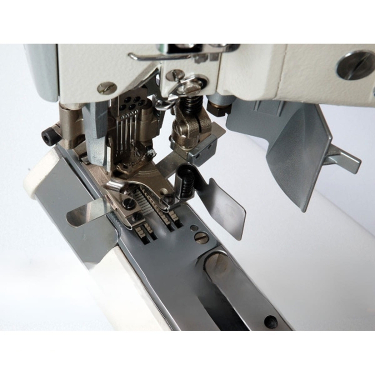 Zbliżenie na mechanizm autolapu ramieniowego SIRUBA D007S-460-02ET/AW1. Widoczne metalowe elementy, w tym igła, stopka i prowadnik materiału, na błyszczącej, stalowej podstawie. Przycisk i sprężyna w tle. Tło jasne, podkreślające detale maszyny.