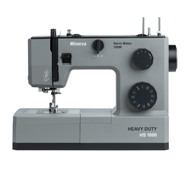 Maszyna do szycia Minerva HS1000 w kolorze szarym, z mechanizmem na górze, pokrętłami do regulacji i widocznym napisem HEAVY DUTY. Ujęcie frontalne, produkt stojący na płaskiej powierzchni. Wysoka moc silnika 100W.