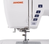 Maszyna do szycia Janome Skyline S6 w kolorze białym, z widocznym logo Janome. Z przodu przyciski do sterowania, w tym START/STOP oraz symbole funkcji. Widoczny stopka maszyny oraz stół szyjący z liniami pomocniczymi.
