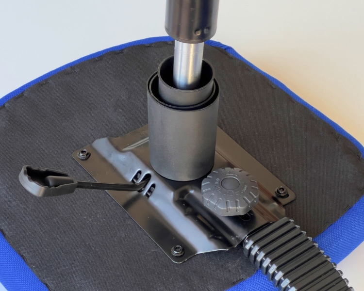 Zbliżenie na mechanizm podnośnika pneumatycznego krzesła KRAFFT BLU. Widoczne elementy: metalowa podstawa, regulacyjny pokrętło i dźwignia do zmiany wysokości. Czarne i niebieskie akcenty tapicerki.
