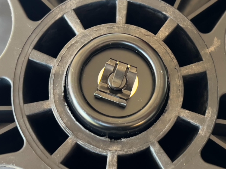 Zbliżenie na podstawkę krzesła przemysłowego KRAFFT BLU z widocznym mechanizmem podnośnika pneumatycznego. Część centralna z czarnym elementem blokującym oraz otworami w okrągłej obudowie. Tło neutralne, skupiające uwagę na detalu.