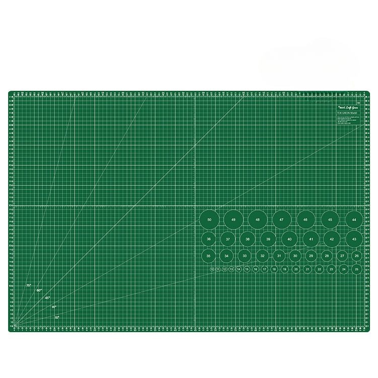 Samoregenerująca mata podkładowa TEXI GREEN w kolorze zielonym, o wymiarach 90x60 cm. Na powierzchni widoczne linie siatki oraz okręgi z numerami, ułatwiające precyzyjne cięcie i pomiar. Ułożona poziomo na białym tle.