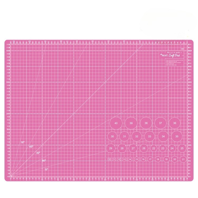 Mata podkładowa TEXI PINK 60x45 cm w kolorze różowym, samoregenerująca. Ujęcie frontalne, z widocznymi liniami siatki oraz oznaczeniami wymiarów i okręgami. Produkt leży na płaskiej powierzchni, co podkreśla jego gładką fakturę.