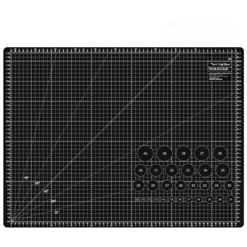 Mata podkładowa TEXI BLACK 60x45 cm w kolorze czarnym, z siatką pomiarową. Widoczne linie w różnych kierunkach oraz okrągłe oznaczenia z numerami. Przeznaczona do cięcia, z samoregenerującą się powierzchnią. Ułożona poziomo na prostym tle.