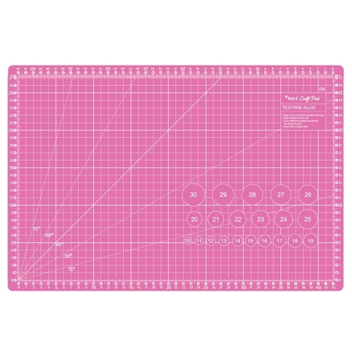 Różowa mata podkładowa TEXI PINK 45x30 cm, samoregenerująca, z siatką w centymetrach oraz kątami, widoczne oznaczenia dla precyzyjnego cięcia, leżąca na prostym tle.