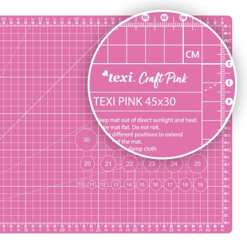 Różowa mata podkładowa TEXI PINK 45x30 cm, samoregenerująca, z siatką pomiarową w centymetrach. Widoczna etykieta z instrukcjami użytkowania oraz oznaczeniami na krawędzi. Ułożona płasko na jasnym tle.
