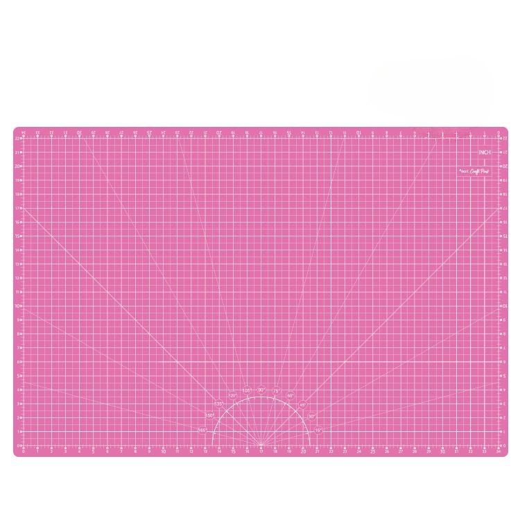 Różowa mata podkładowa TEXI PINK o wymiarach 90x60 cm, samoregenerująca, z siatką pomiarową w centymetrach i calach. Ułożona poziomo, z widocznymi oznaczeniami kątów i linii pomocniczych.