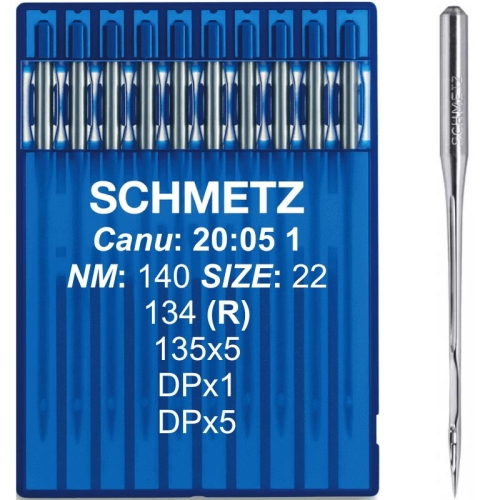 Igły Schmetz 140 z okrągłą kolbą DPx5 135x5 w niebieskim opakowaniu. Widoczne oznaczenia: NM 140, rozmiar 22, DPx1, DPx5. Na zdjęciu jedna igła na prawo od opakowania, pozostałe igły widoczne w przezroczystych przegródkach opakowania.