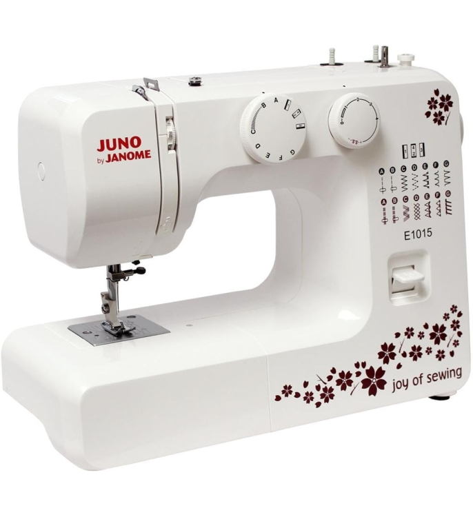Maszyna do szycia Janome JUNO E1015 w kolorze białym z dekoracyjnym wzorem w czerwone kwiaty. Posiada pokrętła do regulacji ściegów i szerokości, metalową płytkę igłową oraz widoczny logo joy of sewing. Ujęcie frontalne, stojąca na płaskiej powierzchni