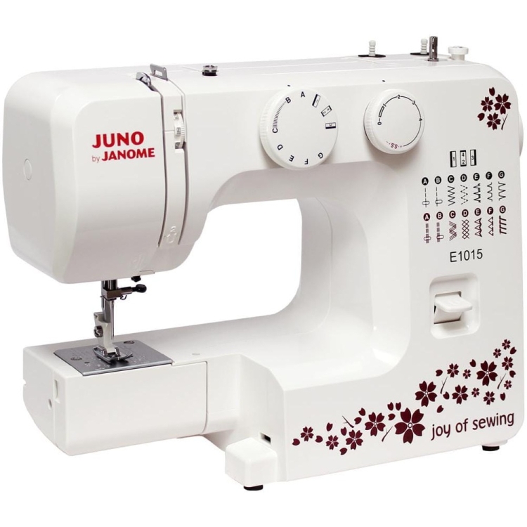 Maszyna do szycia Janome JUNO E1015 w kolorze białym, z ozdobnym wzorem kwiatowym. Frontalny widok pokazuje pokrętła do regulacji oraz panel z wyborem ściegów. Produkt stoi na płaskiej powierzchni, gotowy do użycia.