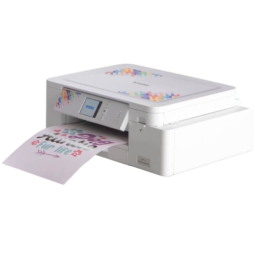 Drukarka Brother SP1 do sublimacji w kolorze białym, z wyświetlaczem LCD i przyciskami, drukująca kolorowe arkusze papieru z grafiką. Ujęcie z boku, pokazujące wydruk w trakcie pracy. Na górze widoczny kolorowy wzór.