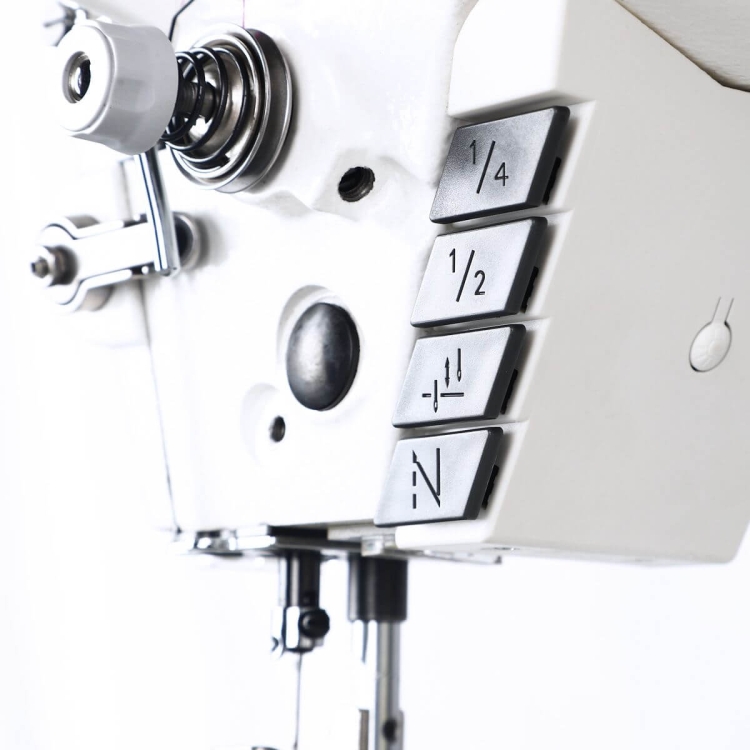 Automatyczna stebnówka TEXI TRONIC 7HF NF PREMIUM EX z powiększonym chwytaczem. Widok z boku, zbliżenie na panel sterujący z przyciskami do regulacji długości ściegu oraz pokrętłem, na białym tle.