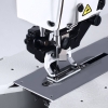 Automatyczna dziurkarka TEXI 781F PREMIUM EX, widok z boku. Na zdjęciu widać metalową stopkę, igłę oraz błyszczący stół roboczy. Urządzenie jest ustawione na jasnym tle, co podkreśla detale konstrukcyjne.