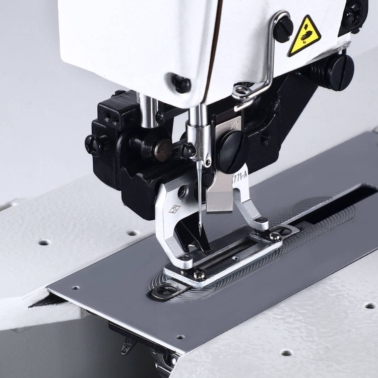 Automatyczna dziurkarka TEXI 781F PREMIUM EX, widok z boku. Na zdjęciu widać metalową stopkę, igłę oraz błyszczący stół roboczy. Urządzenie jest ustawione na jasnym tle, co podkreśla detale konstrukcyjne.