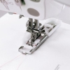 Stopka do automatycznego obszywania dziurek Janome, rotacyjna, o szerokości 7 mm, z metalowym mechanizmem i białą obudową. Ujęcie z bliska, pokazujące stopkę w pozycji roboczej z widocznymi czerwonymi znacznikami na podstawie.