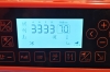 Przemysłowa stebnówka Siruba DL8000-BX2-16Q wyróżnia się nowoczesnym wyglądem i wygodną obsługą. Model ma biały korpus, pomarańczowy panel elektroniczny, wyświetlacz LCD oraz przejrzysty układ przycisków funkcyjnych.