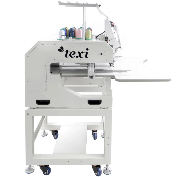 Hafciarka TEXI 1501 XL TS PREMIUM SET, przemysłowa, 15-igłowa, w kolorze białym, z widocznymi szpulami nici w różnych kolorach na górze. Ujęcie z boku, na mobilnym stelażu z kółkami, z szerokim blatem roboczym. Logo texi umieszczone z przodu.