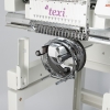 Hafciarka TEXI 1501 XL TS PREMIUM SET, przemysłowa, 15-igłowa. Zbliżenie na mechanizm z przodu maszyny z chromowanymi elementami, w tym ramieniem i rolkami, na białym tle, ukazującym detale konstrukcyjne i precyzyjne wykonanie.