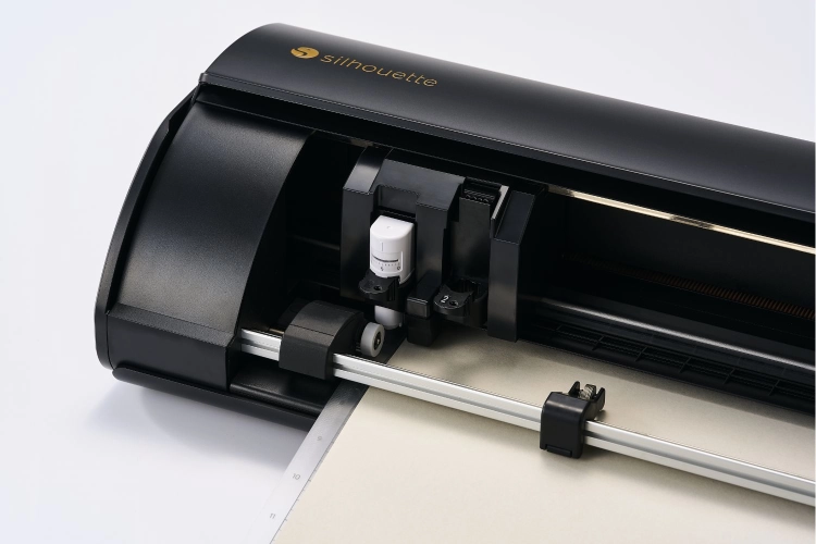 Osiągnij perfekcyjne rezultaty z Silhouette Cameo 5. Tnie ponad 100 materiałów na szerokość 30,5 cm. Wyposażony w podajnik rolki i automatyczny odcinak, ułatwia pracę przy dekoracjach i personalizacji.