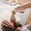 Nóż Fiskars Trigger w codziennej praktyce krawieckiej – szybkie i gładkie cięcie filcu na profesjonalnej macie samogojącej. Ergonomiczny kształt rączki zapewnia pełną kontrolę nad linią cięcia i maksymalny komfort pracy.