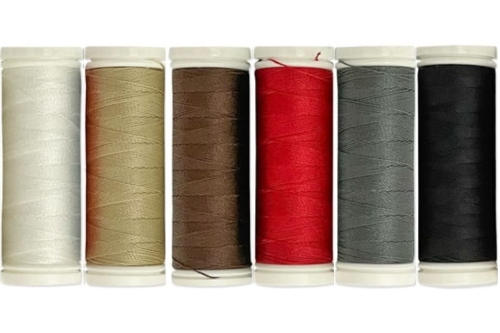 Zestaw 6 nici do szycia skóry Ariadna Leather Tytan 60E/120m, w tym kolory: brązowy, czarny, czerwony, khaki, beżowy i szary. Szpule stoją w rzędzie, każda z widoczną teksturą nici i oznaczeniem koloru.