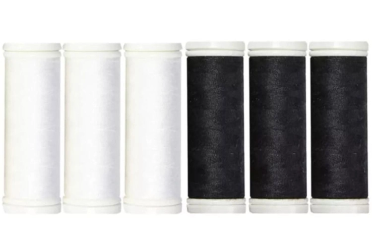 Zestaw 6 elastycznych nici do szycia Ariadna Elastic w kolorach białym i czarnym. Widoczne cztery szpule czarne i dwie białe, umieszczone obok siebie, z wyraźnie oznaczonymi końcówkami. Każda szpula ma klasyczny, okrągły kształt.