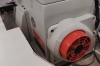 Zbliżenie na silnik w owerloku SIRUBA 757L-516M3-55/ECA-U. Widoczny jest czerwony element napędu servo zamontowanego przy główce maszyny, który wspiera cichszą i oszczędniejszą pracę.