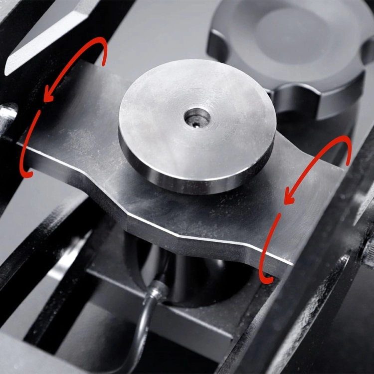 Zbliżenie na metalowy element mechanizmu dociskowego prasy termicznej. Czerwone strzałki wskazują kierunek ruchu części odpowiedzialnej za pracę ramienia i równomierne zamykanie urządzenia. Ujęcie na białym tle.