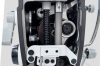 Zbliżenie przedstawia wewnętrzny mechanizm głowicy maszyny JACK. Widoczne są metalowe elementy napędu, wały i połączenia odpowiedzialne za ruch igielnicy oraz prawidłową pracę całego układu szyjącego.
