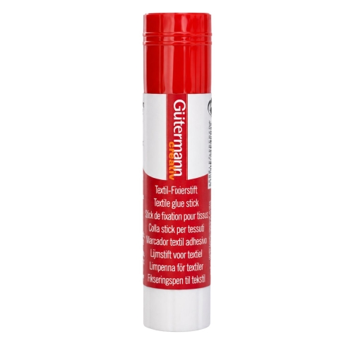 Klej tymczasowy Gutermann Creativ w sztyfcie pokazany w dłoni, bez nasadki i z widoczną powierzchnią klejącą. Zdjęcie dobrze prezentuje kompaktowy format produktu oraz wygodny sposób trzymania podczas pracy z tkaniną.