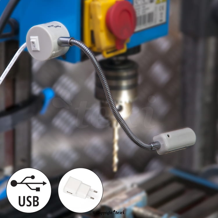 Lampka do maszyn szwalniczych TEXI LED USB, z elastycznym ramieniem. Złącze USB, 12 diod LED, moc 0,6W. Zainstalowana obok maszyny, na tle metalowej powierzchni. Widoczny detal złącza oraz wtyczki.