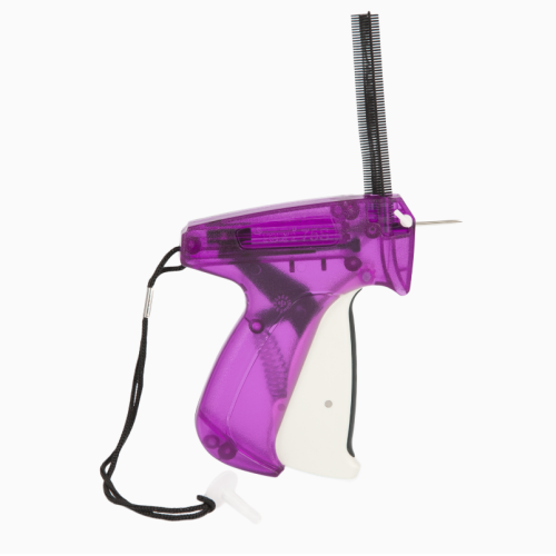 Pistolet do etykietowania Texi 75S GUN w kolorze fioletowym z białymi akcentami. Ujęcie boczne, ukazujące ergonomiczny uchwyt i igłę do etykietowania. Posiada również smycz zabezpieczającą. Widoczne elementy mechaniczne i miejsce na etykietę.