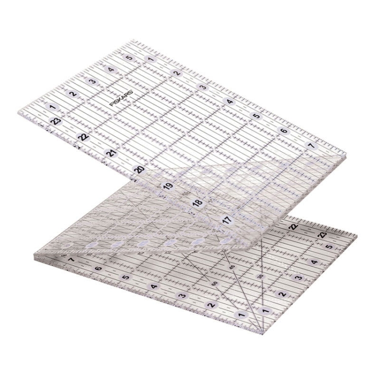 Składana linijka do patchworku i quiltingu Fiskars 1023902 o wymiarach 6x24 cali, wykonana z przezroczystego materiału, z wyraźnymi podziałkami w centymetrach i calach, ukazana w pozycji otwartej, z widocznymi liniami pomocniczymi i kątami.