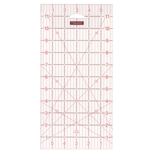 Linijka Fiskars 1004744 do patchworku i quiltingu o wymiarach 150x300 mm, przezroczysta z czerwonymi podziałkami i cyframi, ukazująca kąt 45 stopni. Ujęcie frontalne, linijka leży na białym tle, idealna do precyzyjnego cięcia.