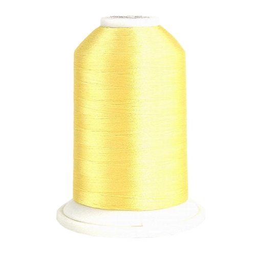 Nić hafciarska Madeira Rheingold Polyneon 40 w matowo cytrynowym kolorze, umieszczona na białej szpulce. Wysokość szpulki z nitką wynosi około 10 cm, a długość nici to 5000 m, idealna do haftu.