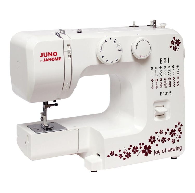 Maszyna do szycia Janome JUNO E1015 w kolorze białym z dekoracyjnym wzorem kwiatowym. Widoczne pokrętła do regulacji oraz panel z różnymi ściegami. Stoi na płaskiej powierzchni, gotowa do użycia.