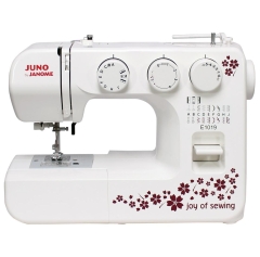 Maszyna do szycia Janome JUNO E1019 w kolorze białym, z dekoracyjnym wzorem w kwiaty. Frontalne ujęcie, widoczne pokrętła do ustawiania ściegów oraz oznaczenia na obudowie. Model posiada stopkę i panel sterujący z łatwym dostępem.