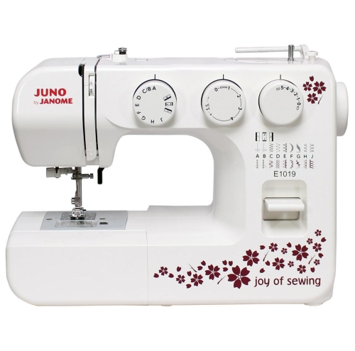 Maszyna do szycia Janome JUNO E1019 w kolorze białym, z dekoracyjnym wzorem w kwiaty. Frontalne ujęcie, widoczne pokrętła do ustawiania ściegów oraz oznaczenia na obudowie. Model posiada stopkę i panel sterujący z łatwym dostępem.