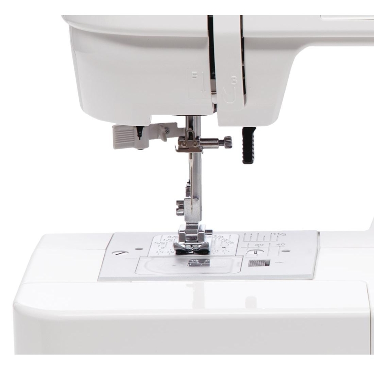 Maszyna do szycia Janome JUNO E1030 w kolorze białym, widok frontalny. Zawiera metalową stopkę, igłę oraz panel z oznaczeniami sticha. Wyposażona w pokrętło do regulacji i uchwyt na nici. Idealna do szycia różnych materiałów.