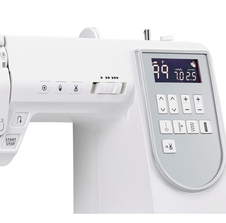 Maszyna do szycia Janome DC6100 w kolorze białym, z wyświetlaczem LCD. Widoczne przyciski sterujące, pokrętło do wyboru ściegów oraz funkcje START/STOP. Po prawej stronie widoczne informacje o ściegu. Stolik w komplecie.