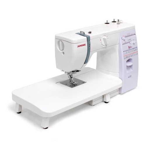 Stolik powiększający pole robocze do maszyn Janome HD523, 415, 419S, 423S. Biały, prostokątny, z czterema stabilnymi nóżkami. Umożliwia wygodne szycie na większej powierzchni. Stolik zamontowany obok maszyny, widoczny z boku.