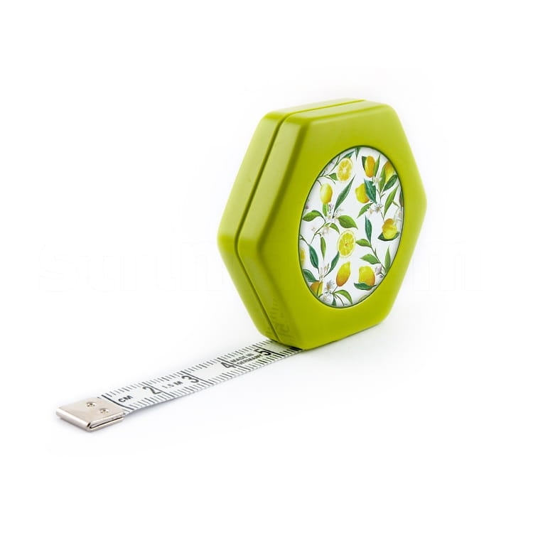 Miara obustronna automatyczna zwijana 150 cm w zielonym, hexagonalnym pudełku z dekoracją w cytryny. Wysuwana taśma z wyraźnymi oznaczeniami cm. Produkt leżący na białym tle, z widocznym końcem taśmy metalowym.