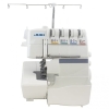 Overlock JUKI MO-735 w kolorze białym z funkcją renderki. Widok z boku, z widoczną igłą, mechanizmem szyjącym oraz czterema szpulami z kolorowymi oznaczeniami. Na górze uchwyt do mocowania nici. Kompaktowa konstrukcja z pojemnikiem na ścinki.